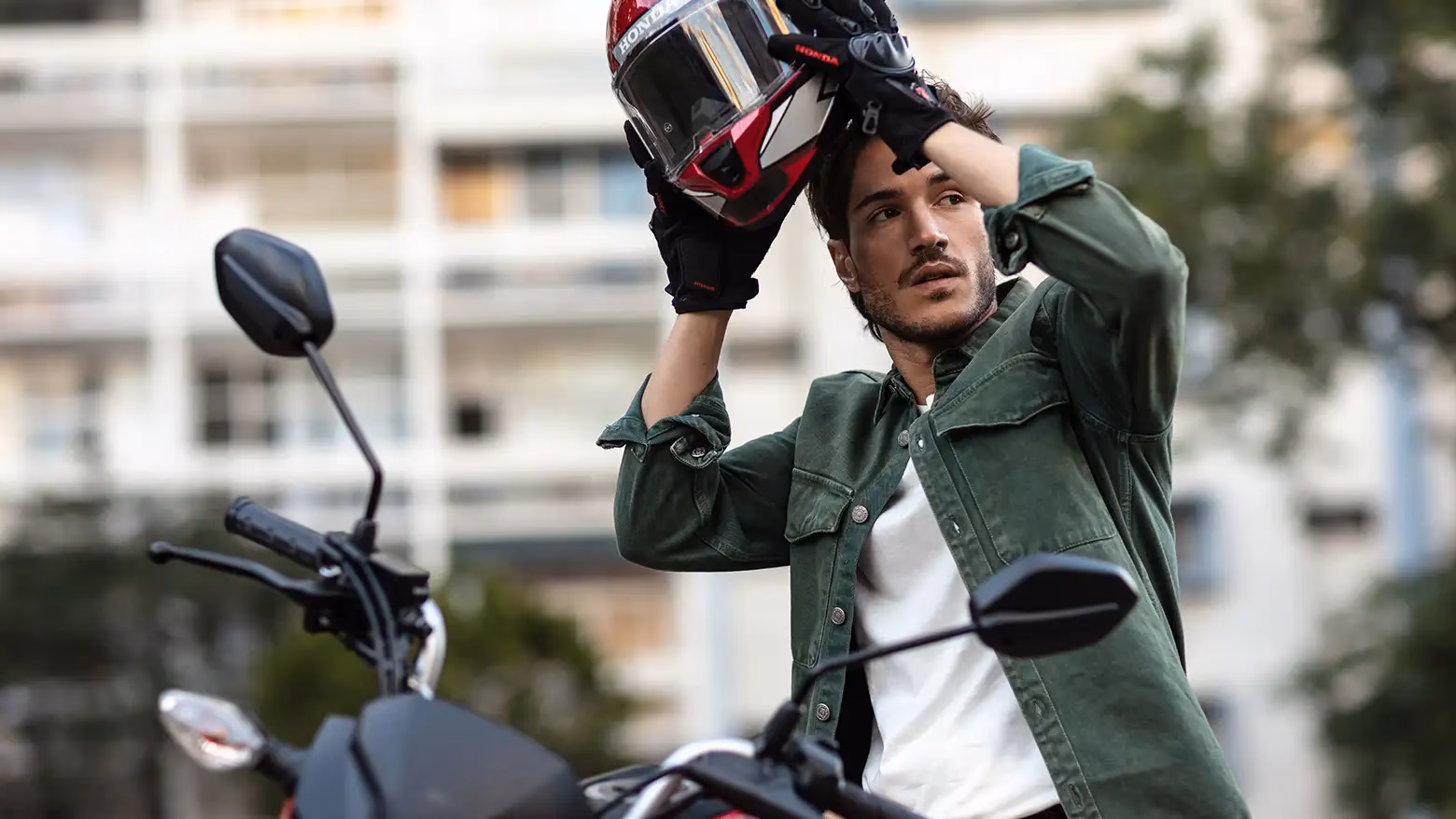 Homem colocando capacete ao lado da Honda CG 160 Fan - 6 de 9