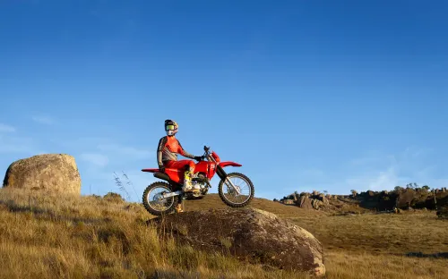 CRF 300F em terreno aberto, destacando o radiador de óleo